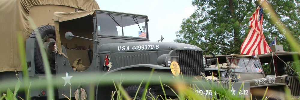 A WWII US truck along with Willys jeeps and the Stars and Stripes